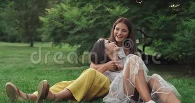 吸引人的是公园里的两位女士，她们一起坐在草地上，笑嘻嘻地在旁边聊天